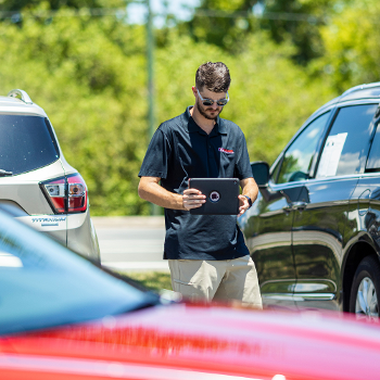 dealer specialties team taking photos of cars in lot